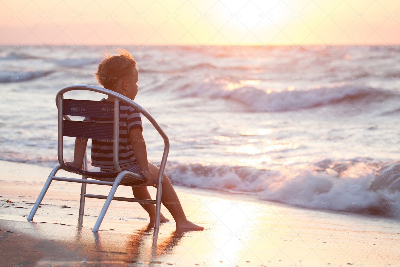 Boy Sitting On The Chair By Sea: Stock Photos