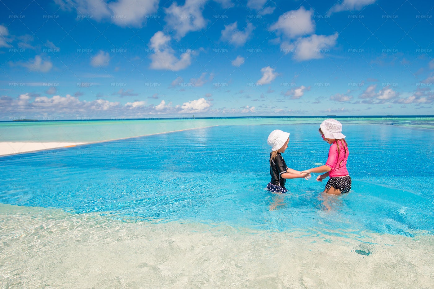 Sisters Playing In Infinity Pool: Stock Photos