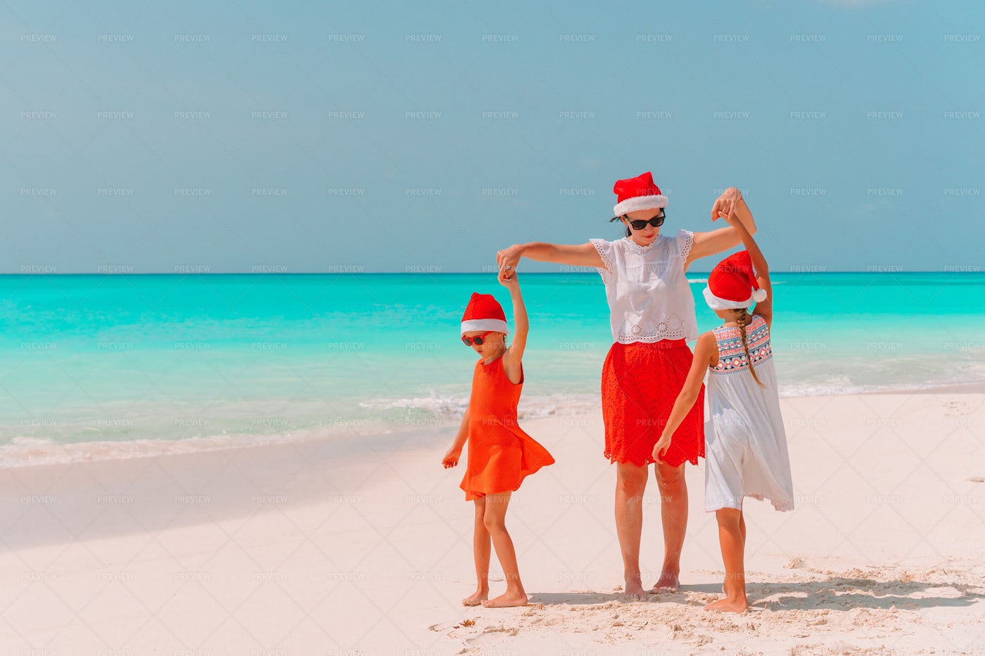 Dancing On Beach With Santa Hats: Stock Photos
