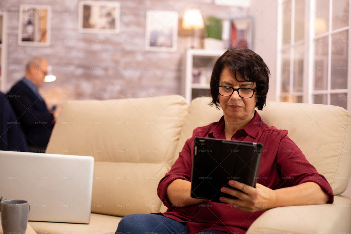 Old Elderly Woman Working On The Sofa: Stock Photos