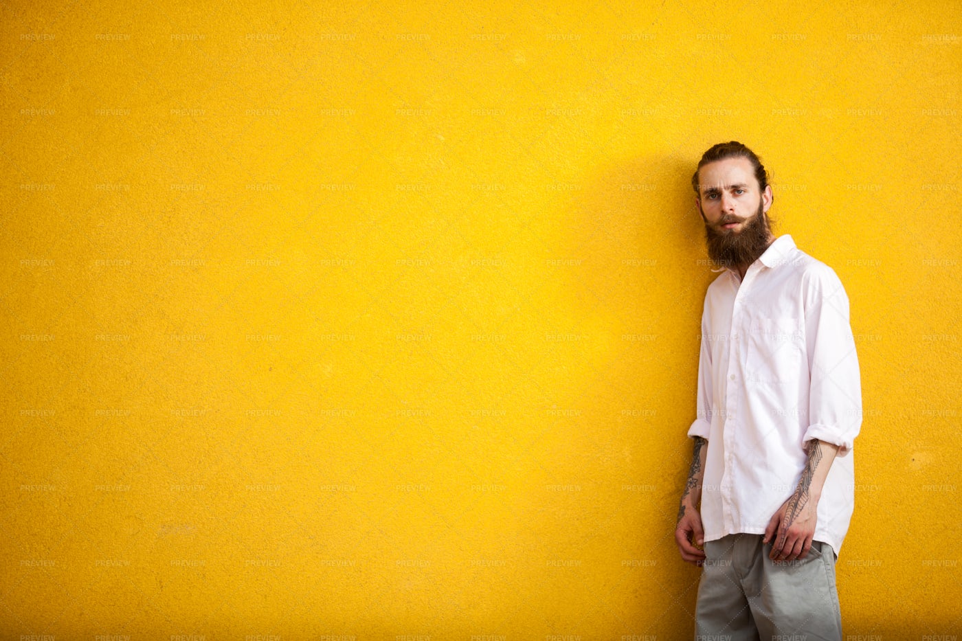 Tattooed Man Against Yellow Wall: Stock Photos