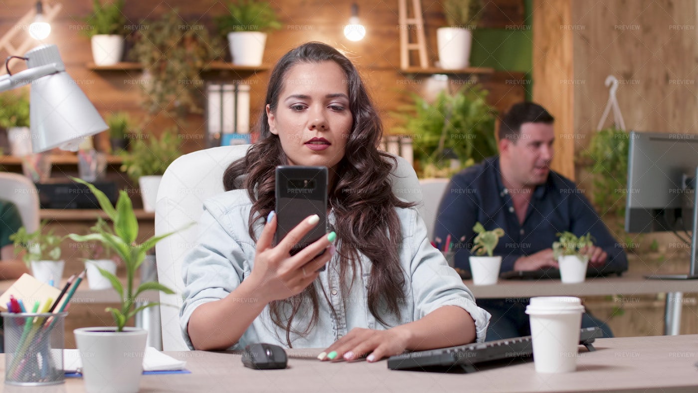 Looking At Phone In Office: Stock Photos