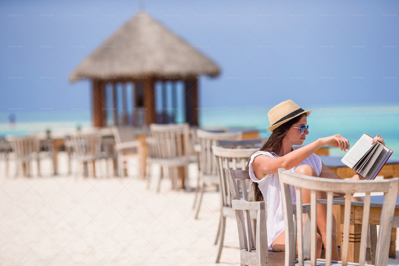Reading At Beachfront Restaurant: Stock Photos