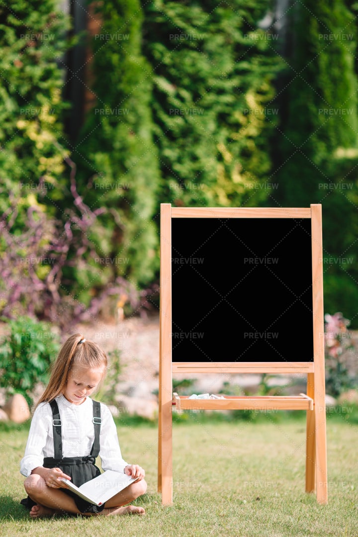 Reading Beside A Chalkboard: Stock Photos
