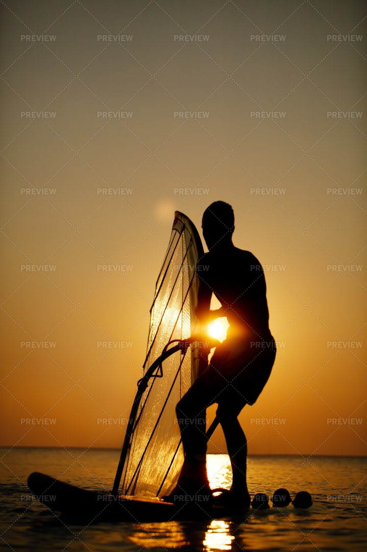 Man Sailboarding At Sunset: Stock Photos
