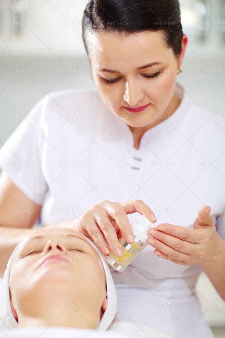 Cosmetician Applying Facial Treatment: Stock Photos