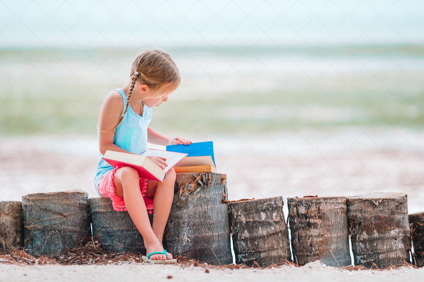 Girl Reading By The Sea: Stock Photos