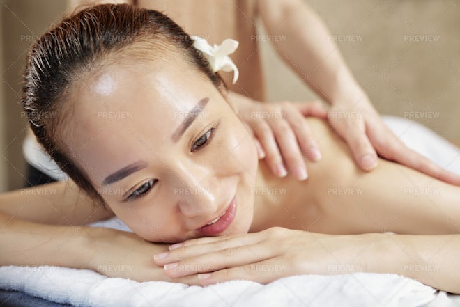 Body care. Relaxed woman enjoying back massage Stock Photo by