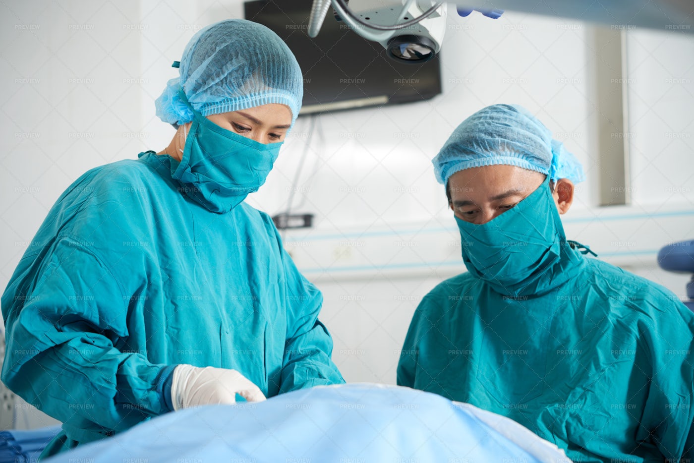 Surgeons Operating In Operating Room: Stock Photos