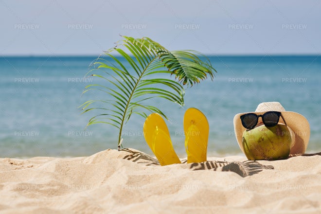 Summer beach bag and accessories - straw hat, flip flops and sunglasses on sandy  beach and azure sea on background, Stock image