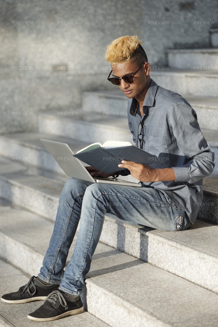 Black Man Reading Notes In His Planner: Stock Photos