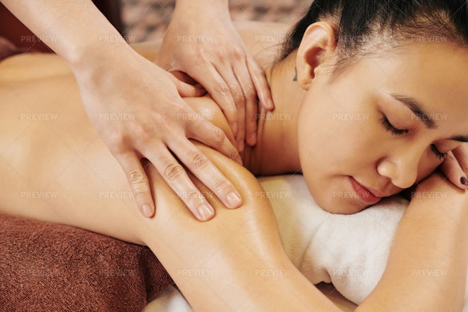 Body care. Relaxed woman enjoying back massage Stock Photo by