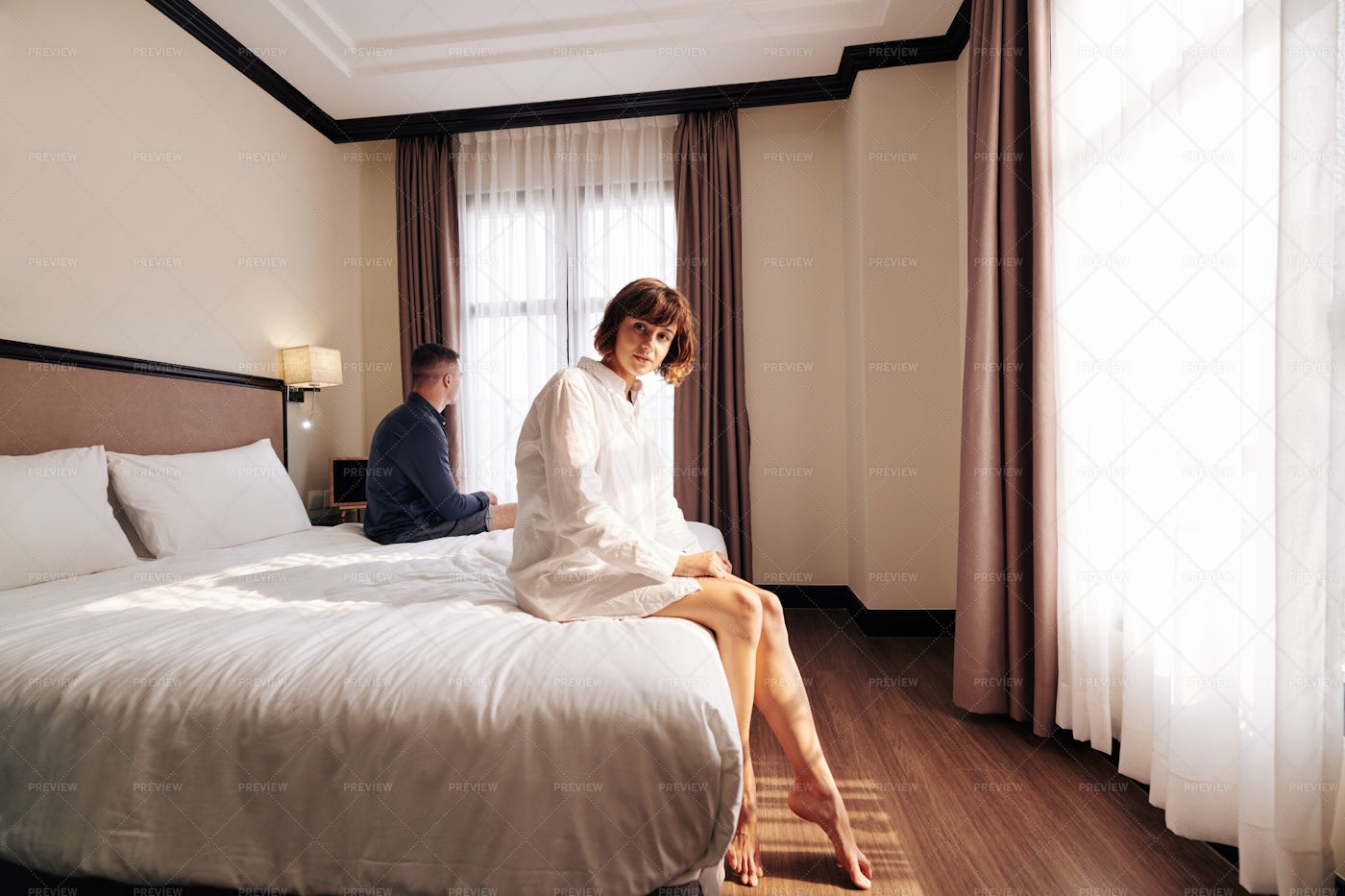 Pretty Woman Sitting On Hotel Bed: Stock Photos