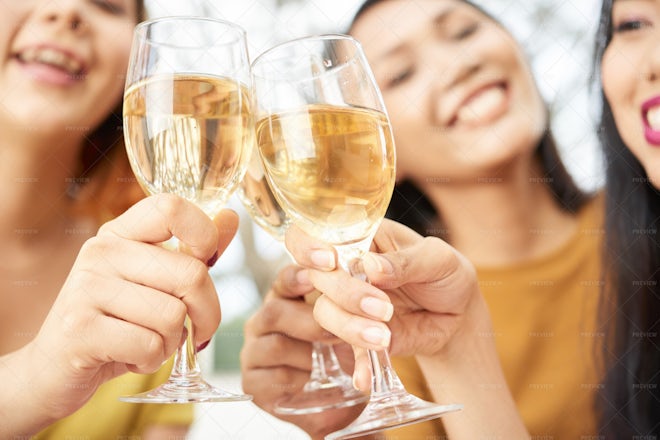 Businesswoman drinking from large wine glass with straw stock