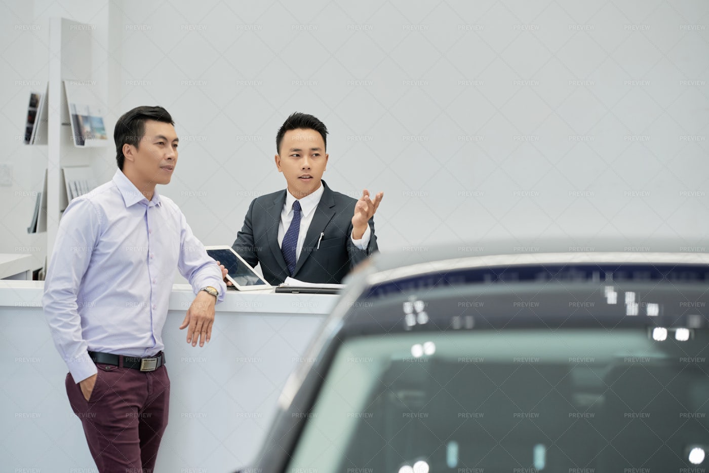 Salesman Showing Cars To Customer: Stock Photos