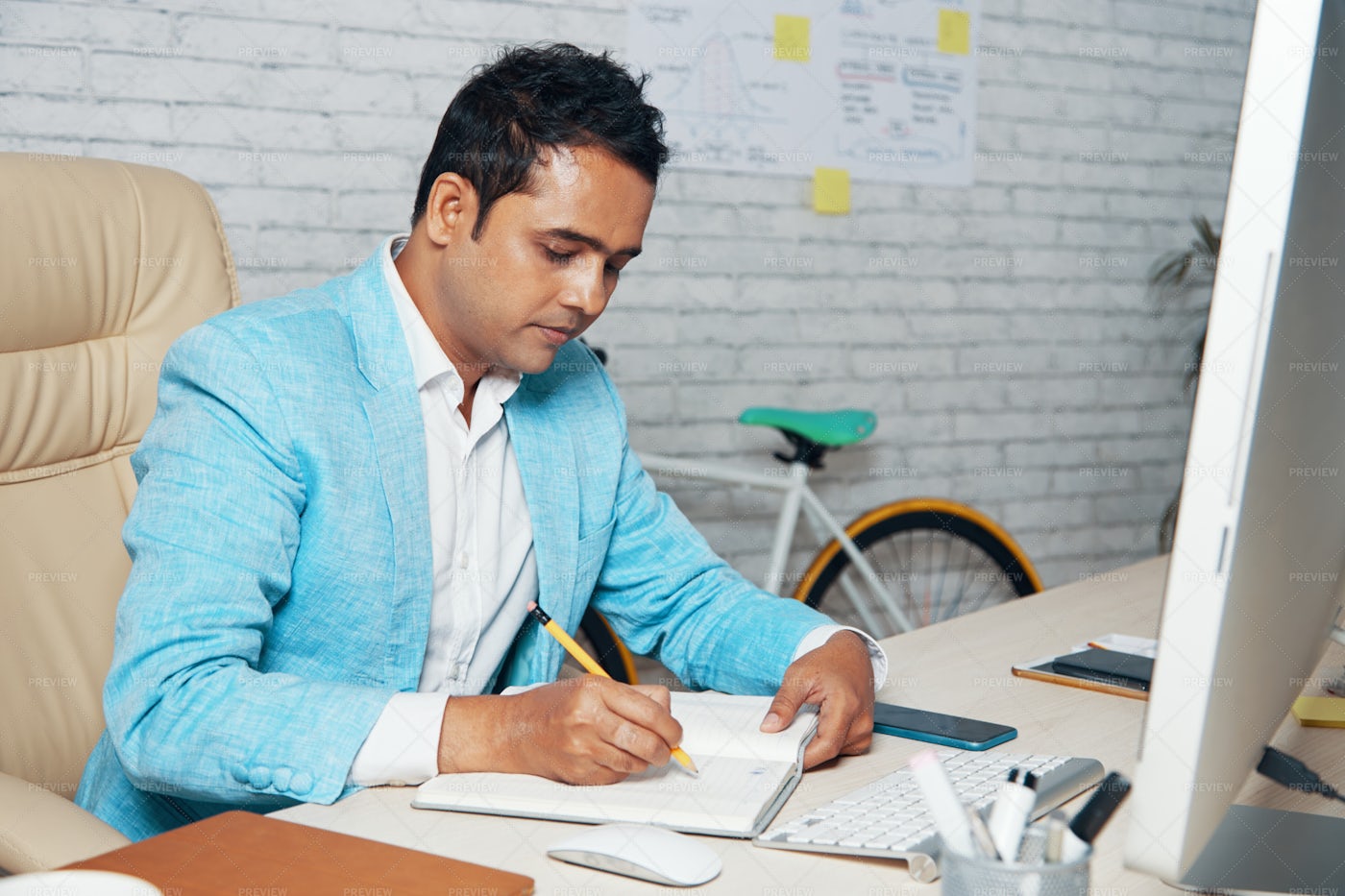 Manager Making Notes In Notepad At: Stock Photos