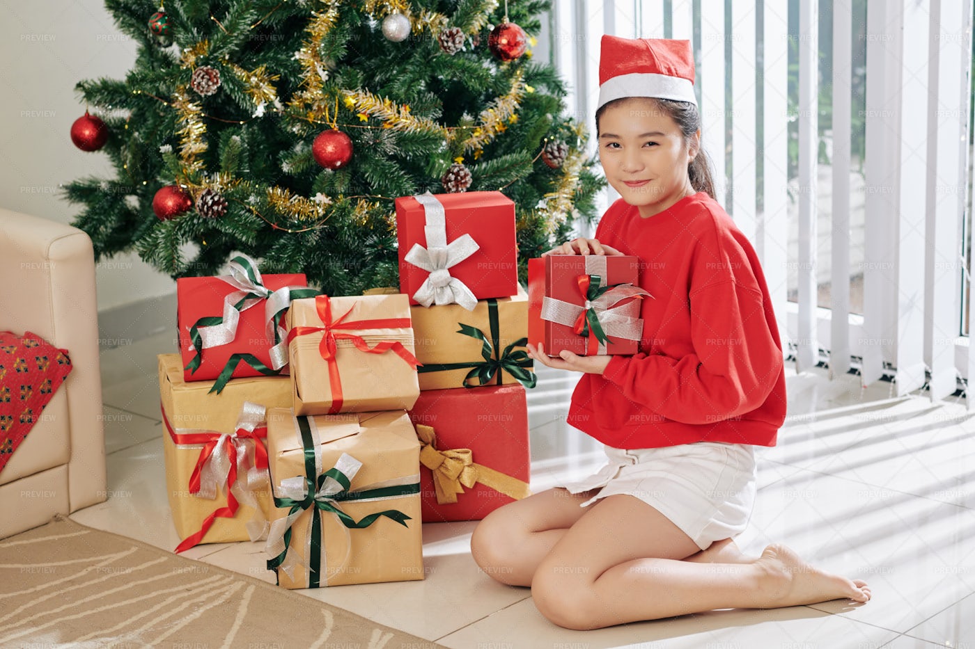 Curious Girl Opening Presents: Stock Photos