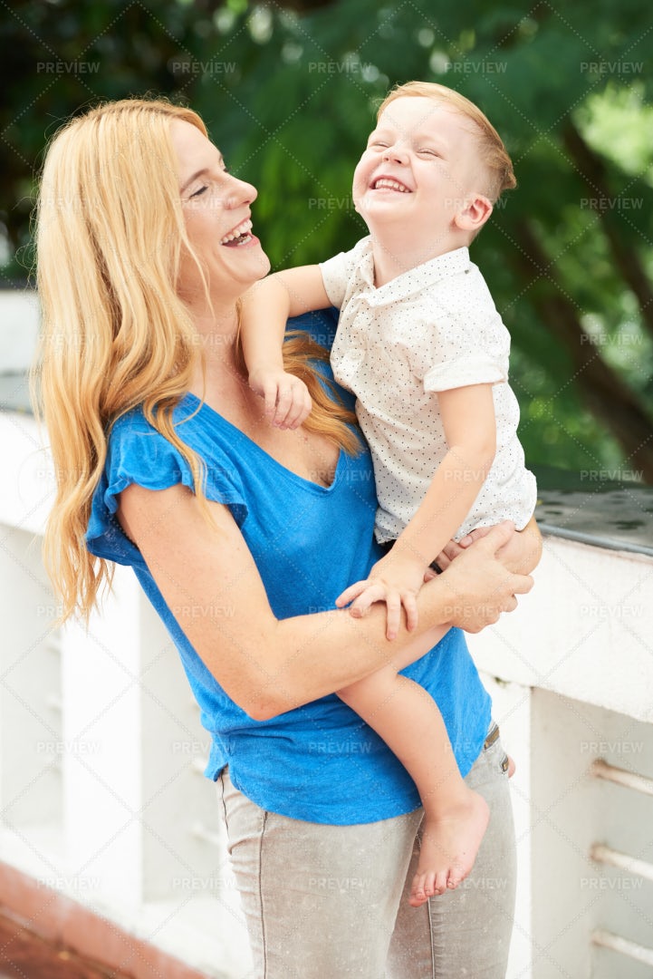 Mother Carrying Son: Stock Photos