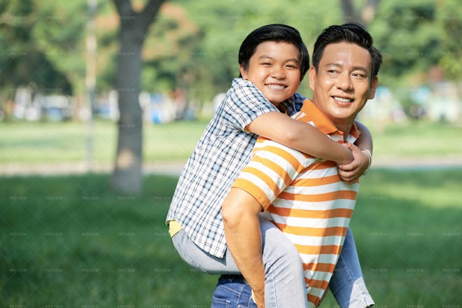 Happy mother giving her son a piggyback ride in the city stock photo