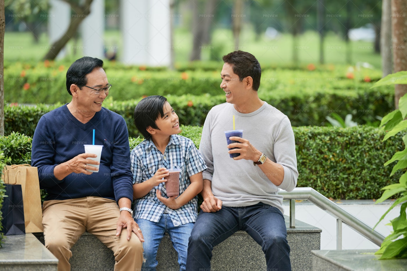 Asian Family Drinking In Park: Stock Photos