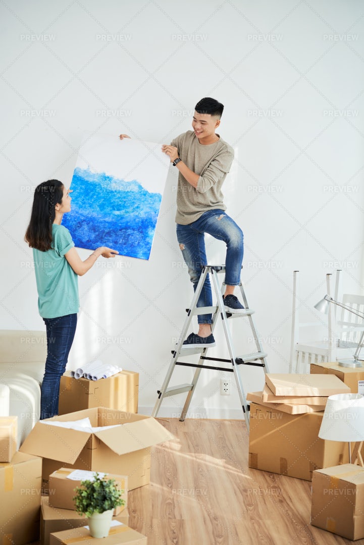 Woman Helping Man To Hang Picture: Stock Photos