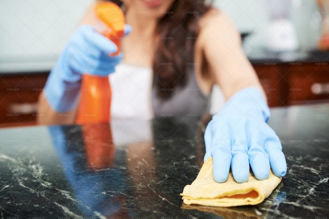 Housewife cleaning table Stock Photo by DragonImages