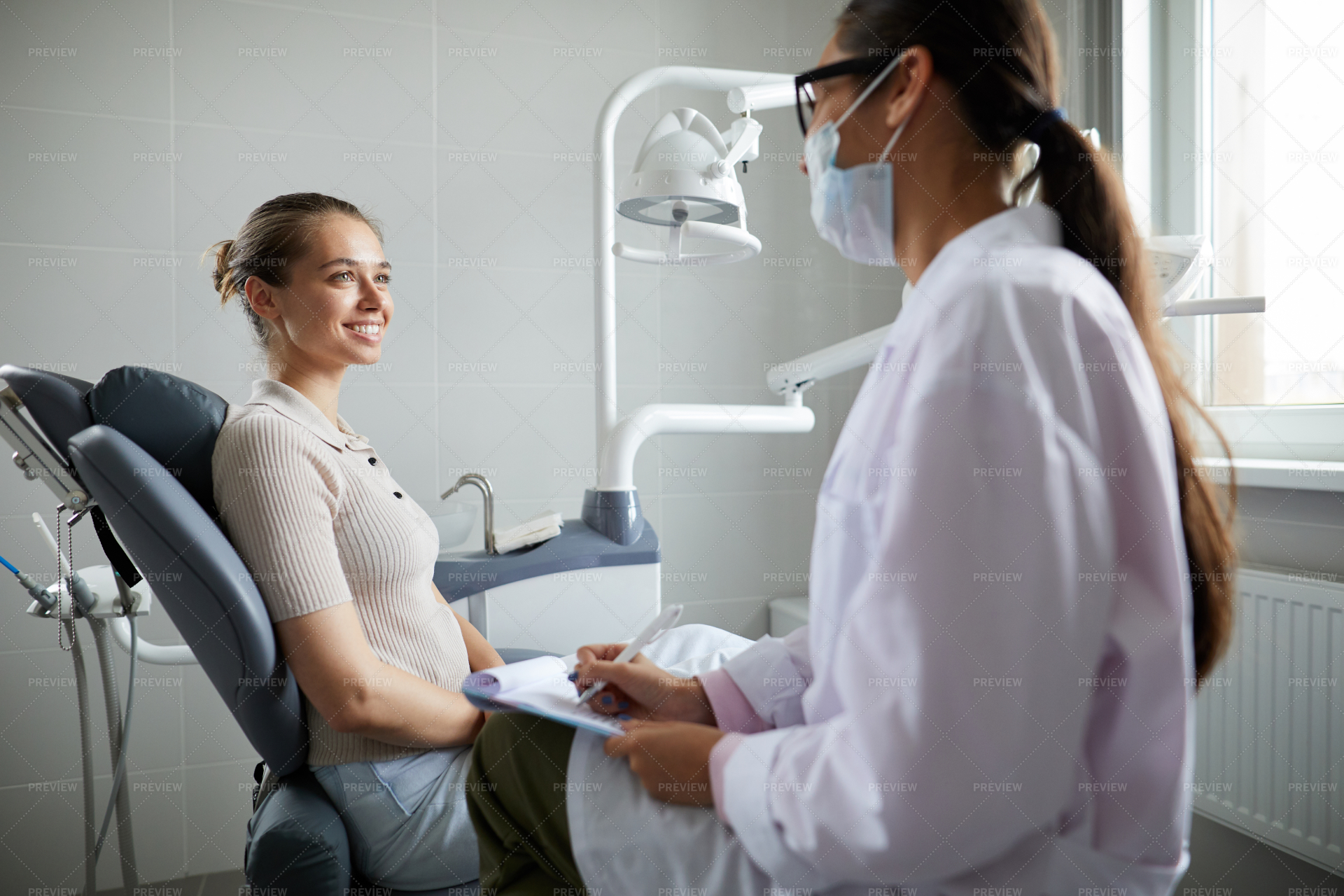 Dentist Consulting Smiling Young... - Stock Photos | Motion Array