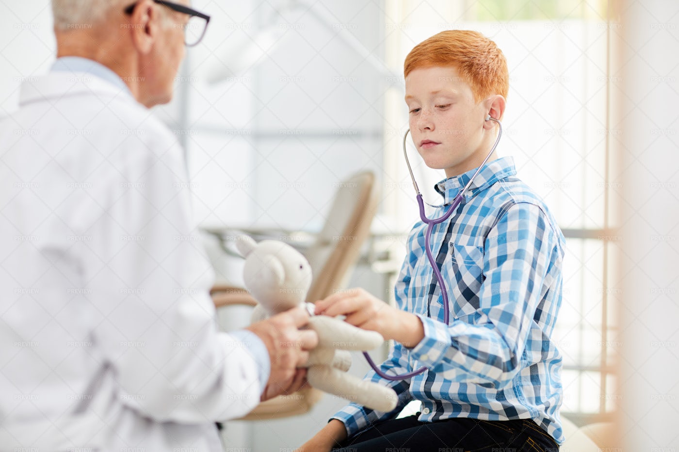 Boy Using Stethoscope In Doctors...: Stock Photos