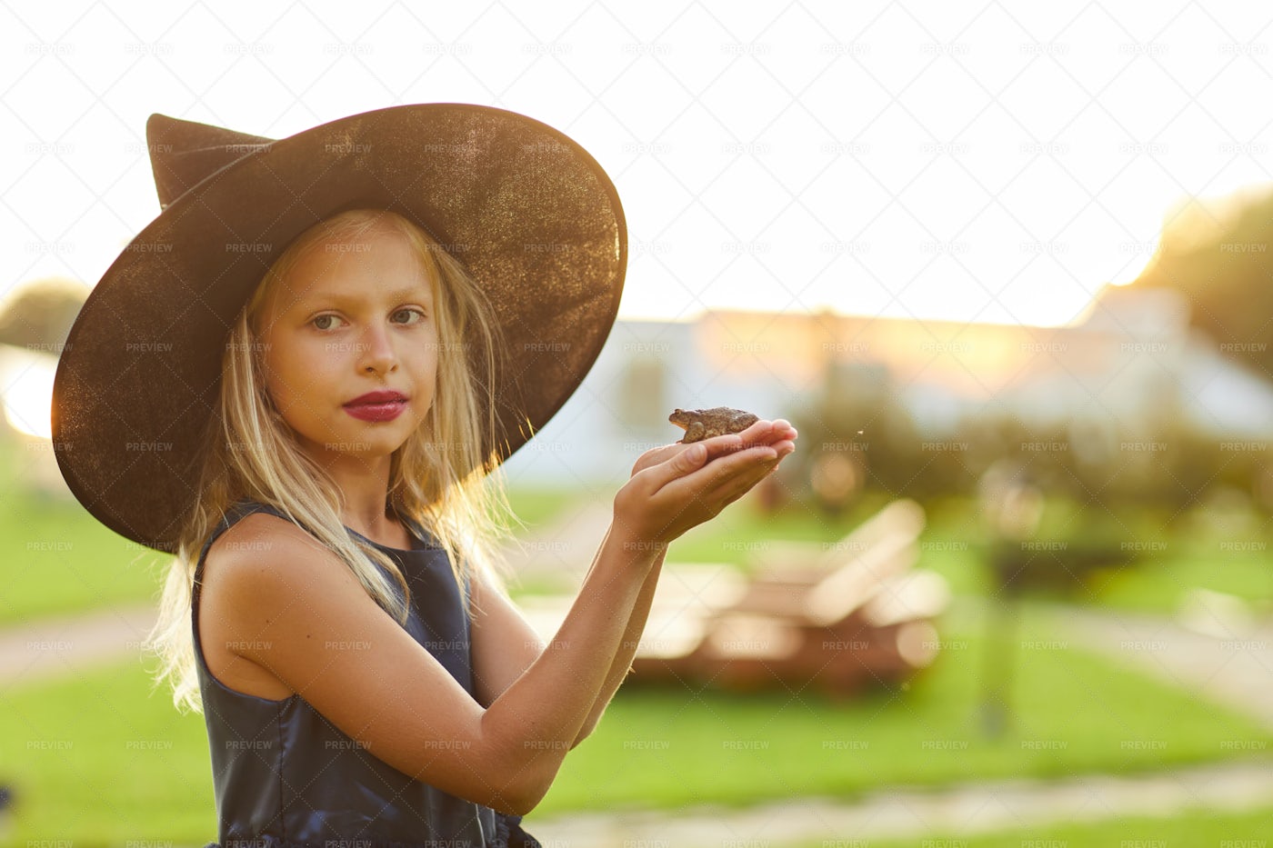 Cute Little Witch Holding Frog: Stock Photos