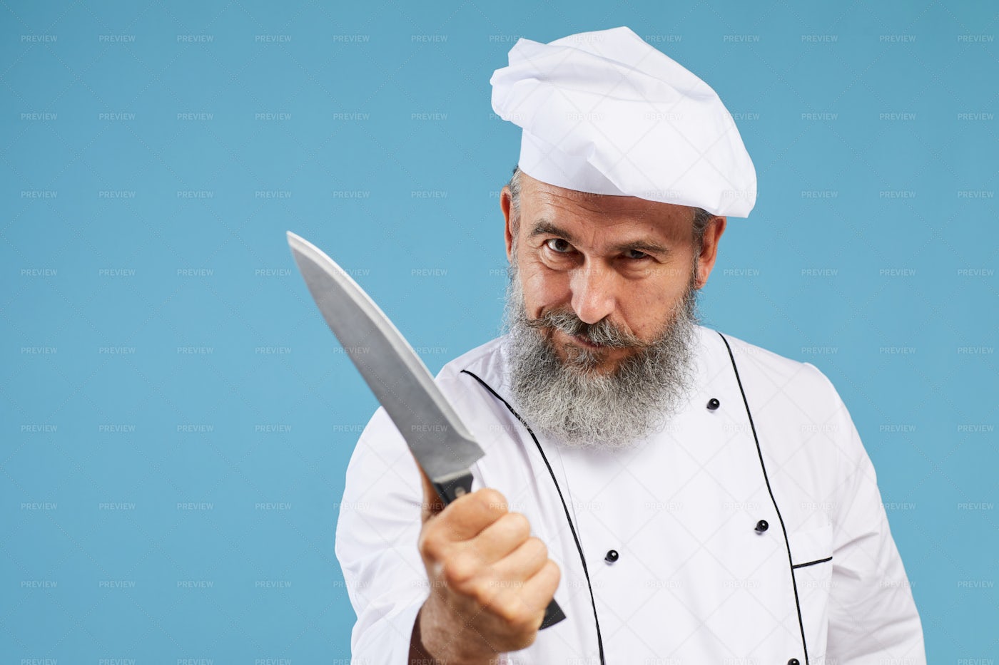 Chef Holding Sharp Knife On Blue: Stock Photos