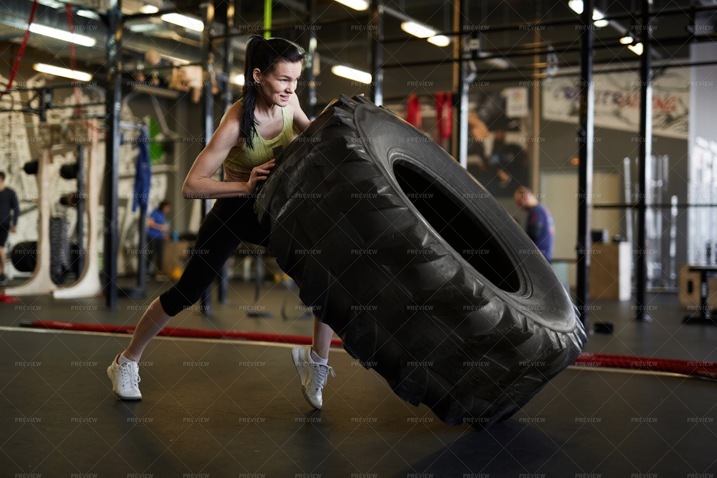Woman Flipping Truck Tire In Gym: Stock Photos