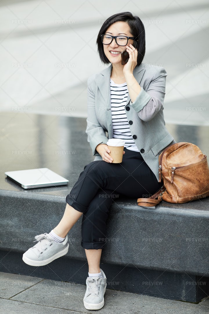 Asian Woman Speaking By Smartphone...: Stock Photos