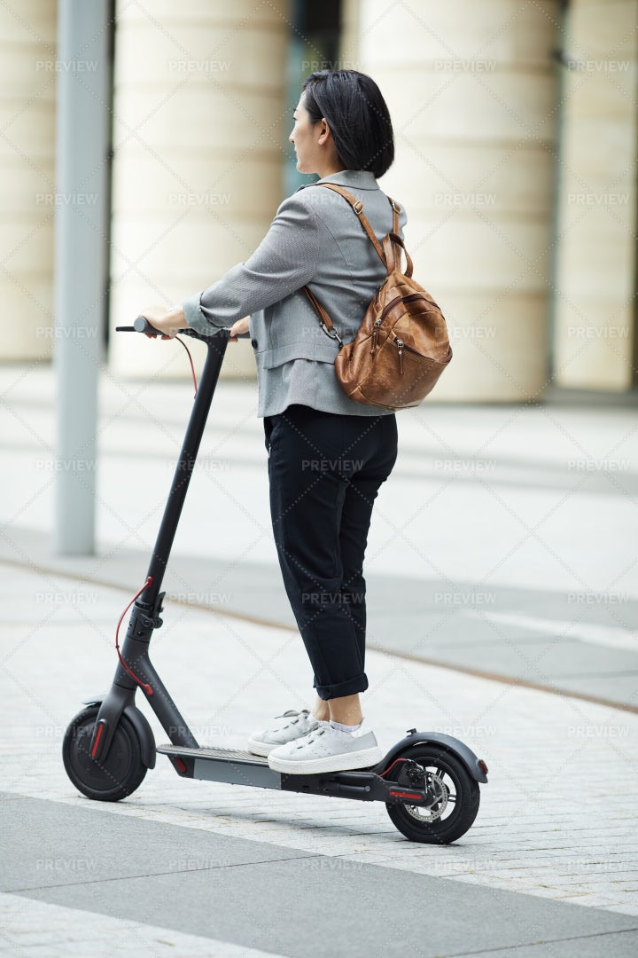 Asian Woman Riding Electric Scooter: Stock Photos