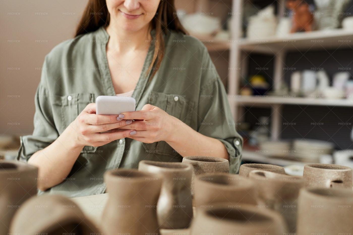 Female Potter Using Smartphone: Stock Photos