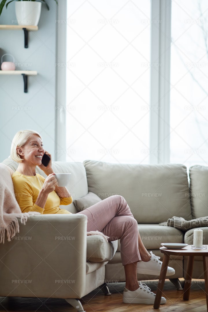 Woman Talking On Phone In Living...: Stock Photos