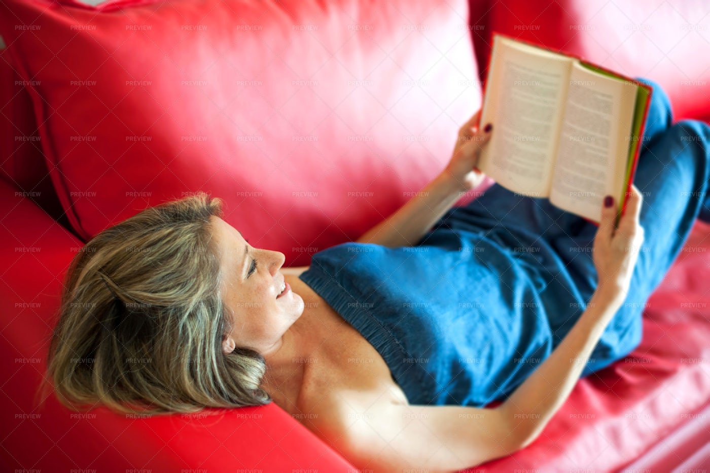 Woman Smiling As She Reads: Stock Photos