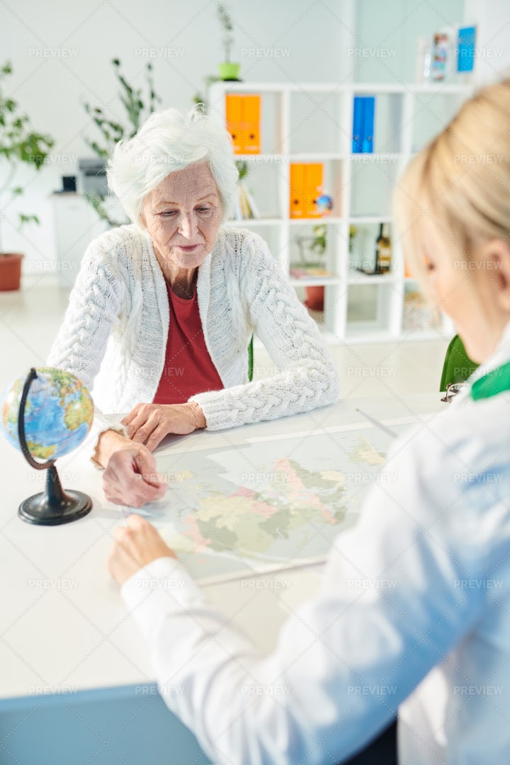 Elderly Lady Asking Travel Agent...: Stock Photos