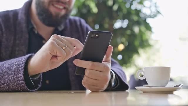 Man Using a Smartphone In Cafe: Stock Video