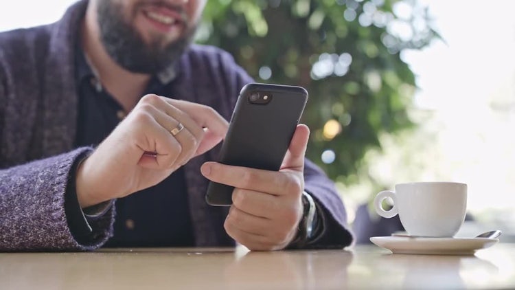 Man Using a Smartphone In Cafe: Stock Video