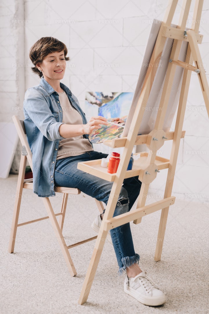 Female Artist Painting At Easel: Stock Photos