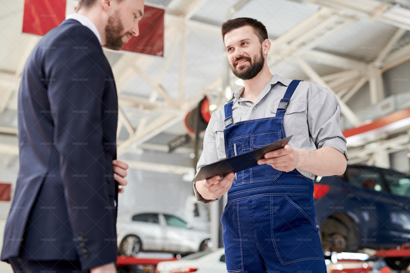 Smiling Mechanic Giving Contract To...: Stock Photos