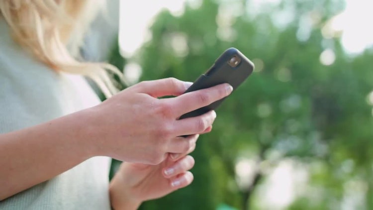 Lady Using A Mobile Phone Outdoors: Stock Video