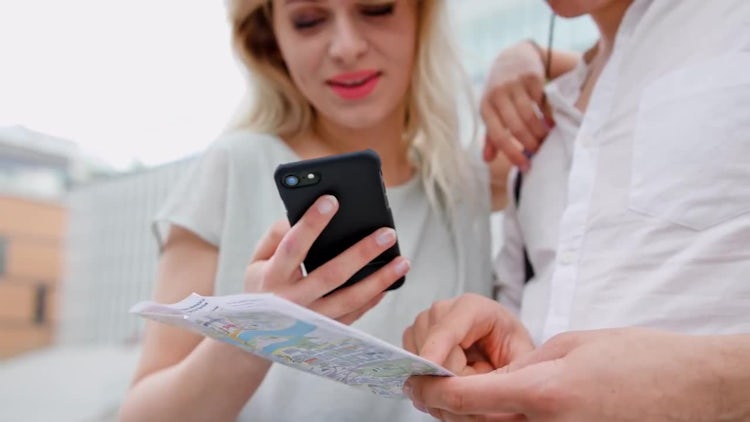 A Young Couple Using a Mobile Phone Outdoors: Stock Video