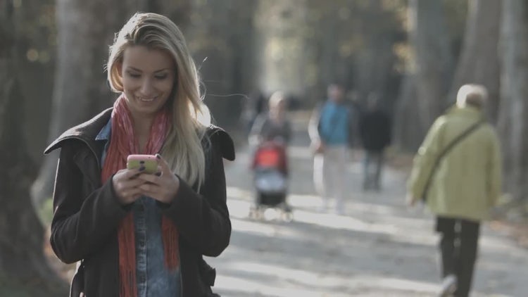 Lady In The Park Using A Smartphone: Stock Video