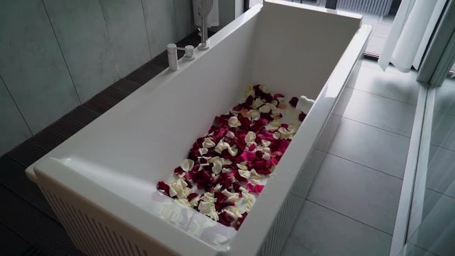 Romantic bathtub with flower petals and , Stock Video