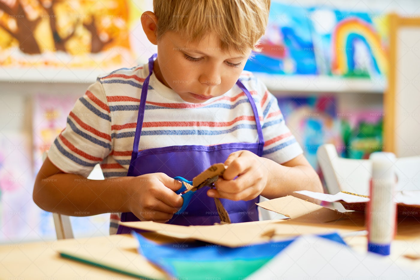 Little Boy Cutting Paper In Craft...: Stock Photos