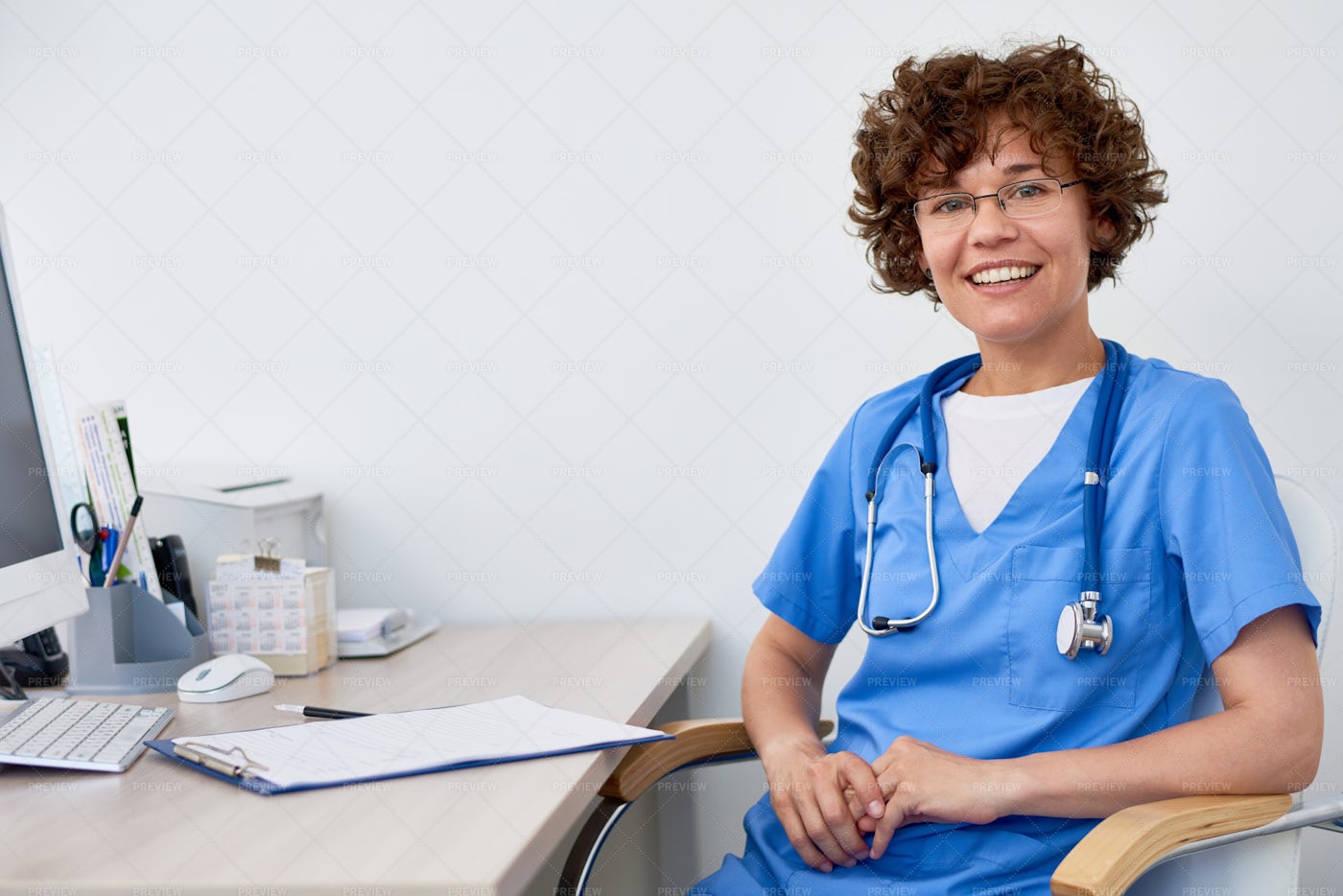 Young Female Doctor At Desk In...: Stock Photos