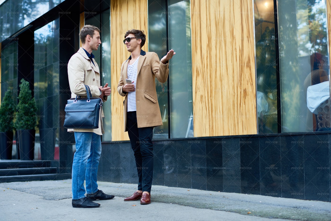 Two Stylish Men Chatting Outdoors: Stock Photos