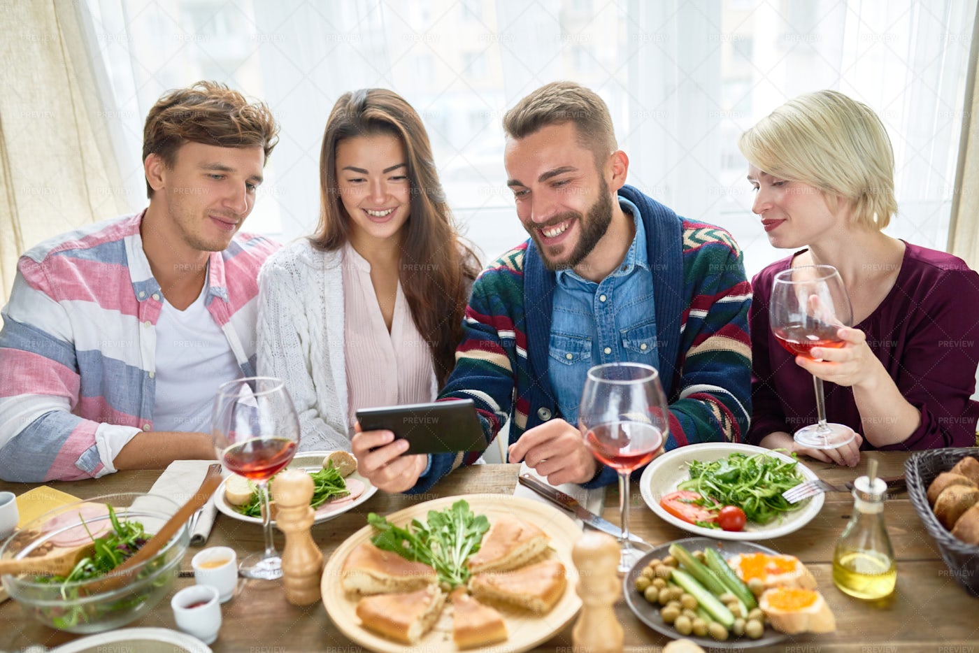 Friends Watching Video At Dinner...: Stock Photos