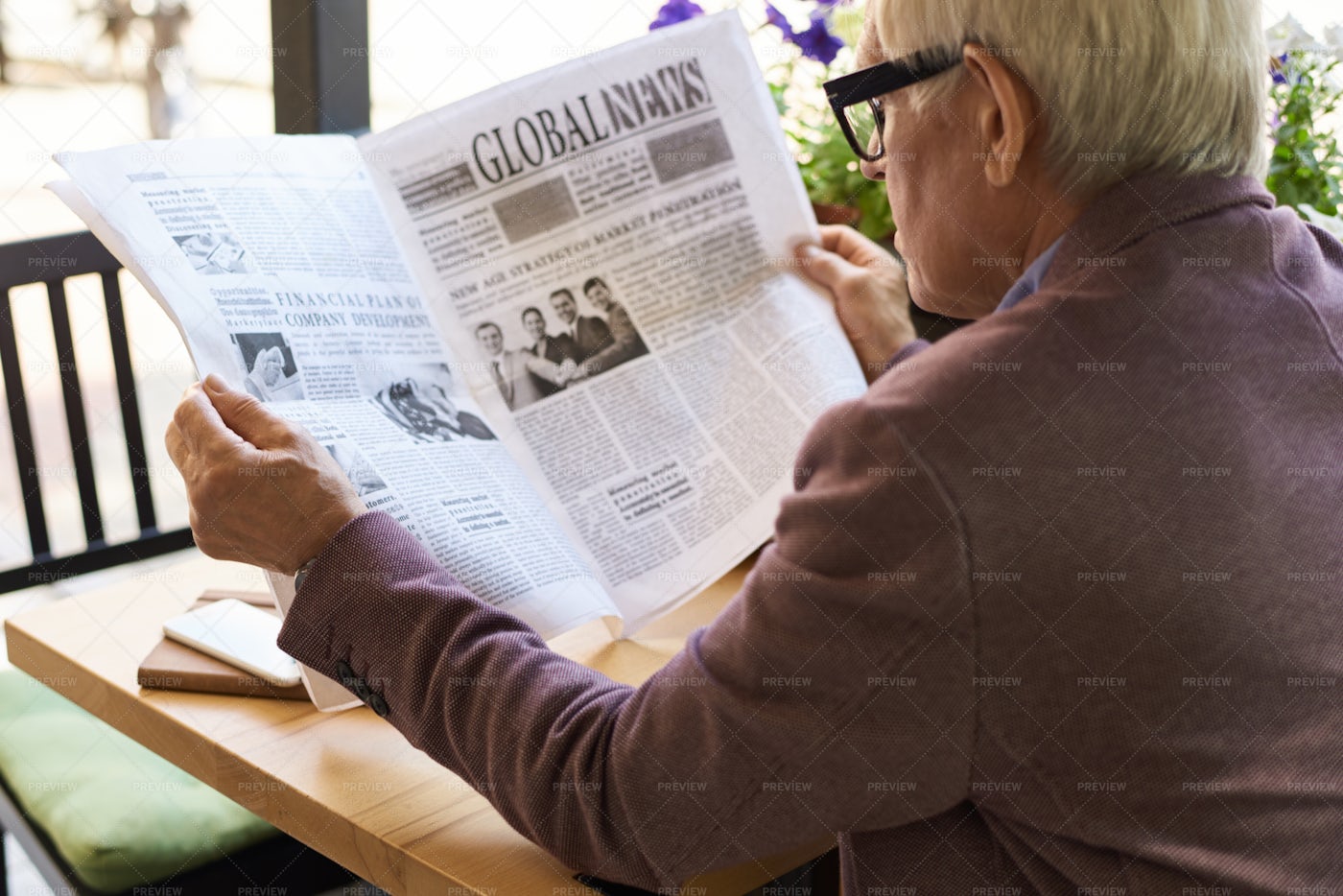 Senior Man Reading Newspaper At...: Stock Photos
